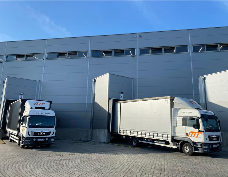 Pojazdy MASTER TRANS przy rampach załadunkowych hali magazynowej